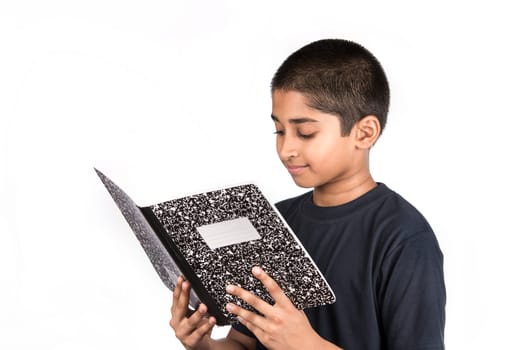 An handsome Indian kid doing his homework diligently