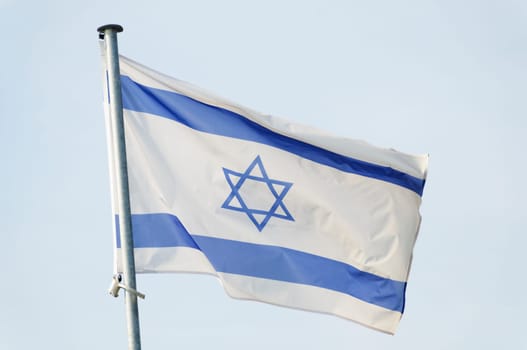 Israeli flag on a mast, sky background