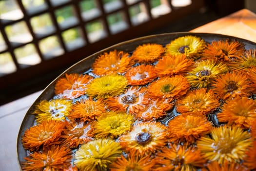 Orange and yellow flowers in water, indoor photography