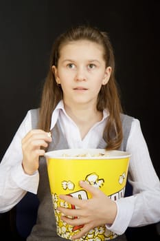 girl with popcorn on a black background