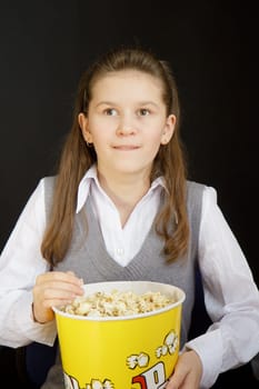 girl with popcorn on a black background