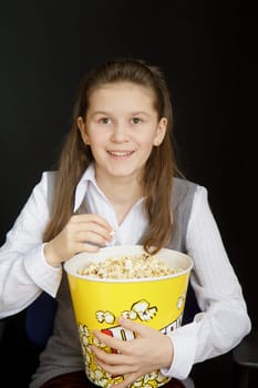 girl with popcorn on a black background