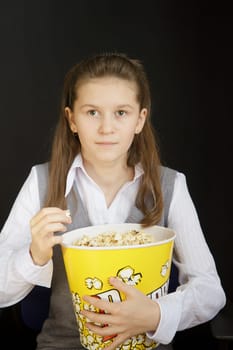 girl with popcorn on a black background