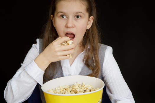 emotional girl with popcorn on a black background