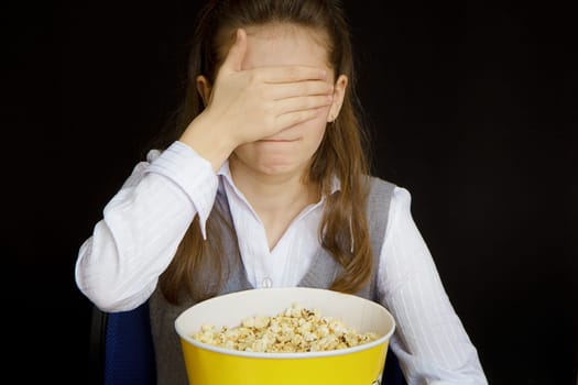 girl in a movie theater closes her eyes