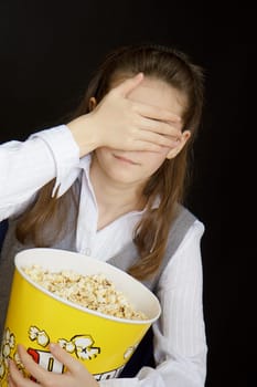 girl in a movie theater closes her eyes