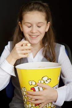 girl with popcorn on a black background