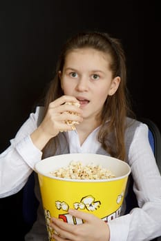 emotional girl with popcorn on a black background