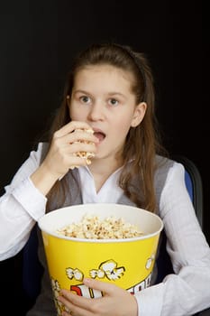 emotional girl with popcorn on a black background