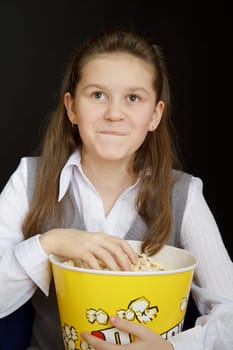 girl with popcorn on a black background