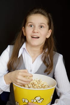 emotional girl with popcorn on a black background