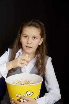 emotional girl with popcorn on a black background