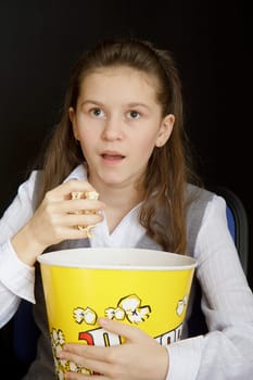 emotional girl with popcorn on a black background