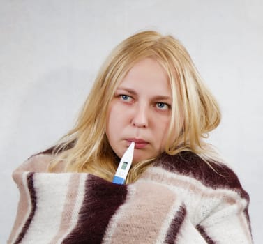 girl with a thermometer, wrapped in a blanket