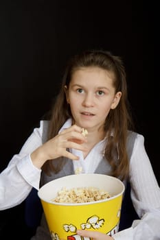 emotional girl with popcorn on a black background