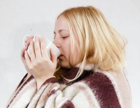girl with a cup wrapped in a blanket. white background