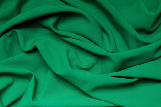 The folds of a bright green cloth. Abstract Background