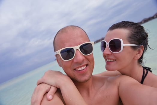 happy young couple have fun and relax at summer vacation on background maldives travel location and beautiful white sand beach