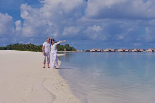 happy young couple have fun and relax at summer vacation on background maldives travel location and beautiful white sand beach