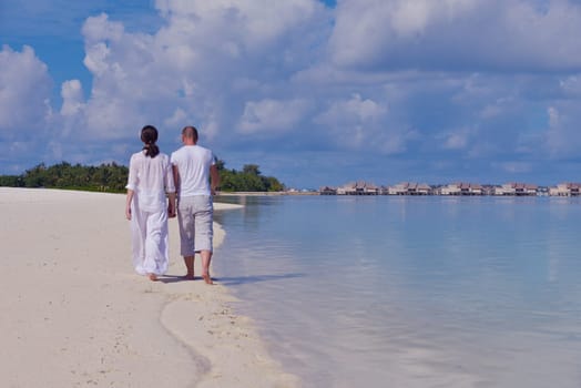 happy young couple have fun and relax at summer vacation on background maldives travel location and beautiful white sand beach