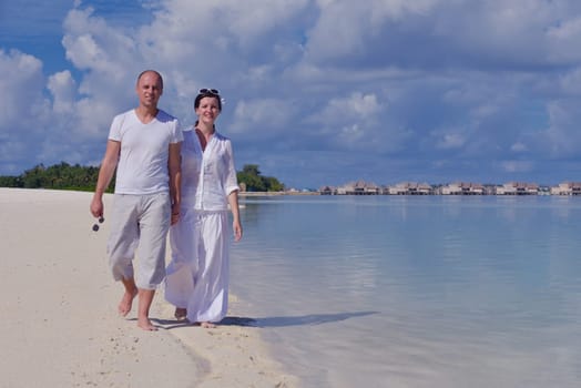 happy young couple have fun and relax at summer vacation on background maldives travel location and beautiful white sand beach