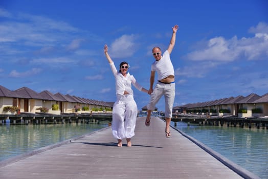 happy young couple have fun and relax at summer vacation on background maldives travel location and beautiful white sand beach