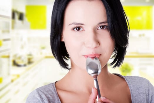 young smiling woman with spoon (pleasure from eating)