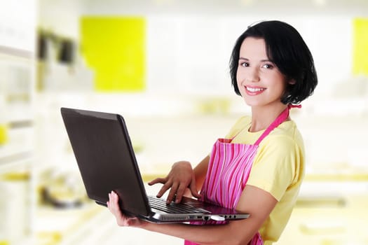modern housewife or female worker with laptop wearing pink apron