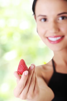 happy young woman with strawberry. focused on strowberry.