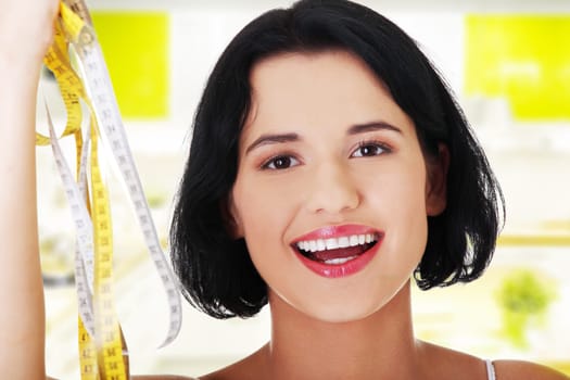 Pretty smiling woman holding measurement types