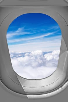 View through airplane window, sky over the clouds