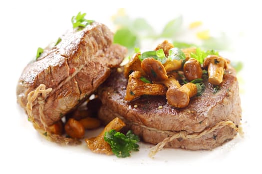 Two succulent thick grilled medallions of fillet steak tied with string and topped with fried mushrooms served on a white platter