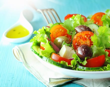 Closeup view of a plate of healthy fresh Greek feta and olive salad with crisp lettuce and tomato for a delicious Mediterranean cuisine