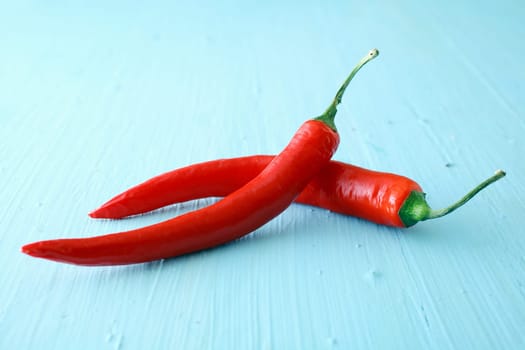Two red hot jalapeno chili peppers used as a pungent spicy ingredient in cooking or dried and crushed to produce cayenne pepper