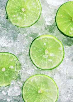 Close-up of five fresh slices of green limes over crushed ice cubes