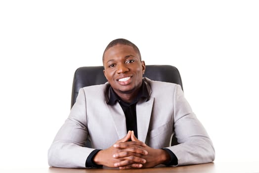 Happy successful businesman at the desk. Isolated on white.