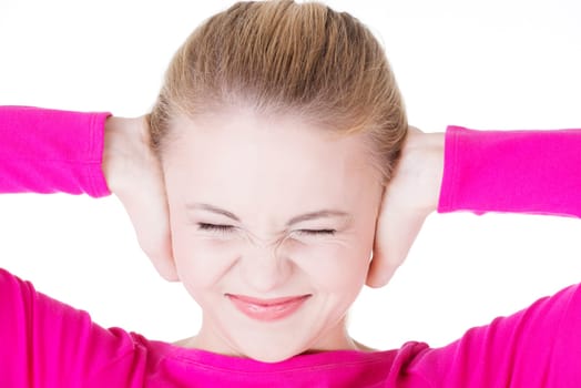 Closeup of frustrated young woman holding her ears, isolated on white
