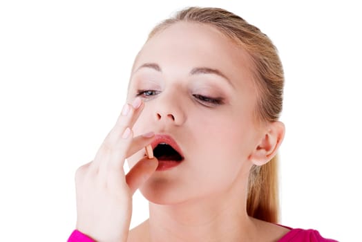 Blond woman taking pill, isolated on white.