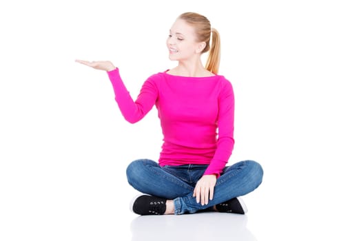 Happy , excited young woman presenting copy space on her palm, isolated on white