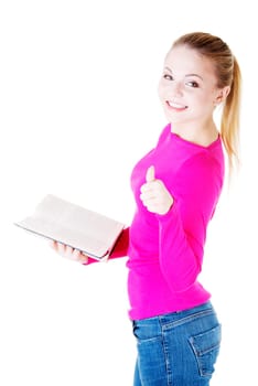 Attractive young student woman with book gesturing OK, isolated on white