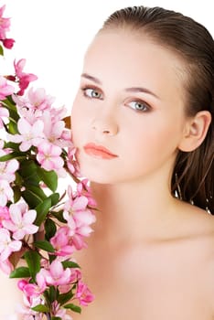 Beautiful face of spa woman with healthy clean skin and pink flowers. Isolated on white.