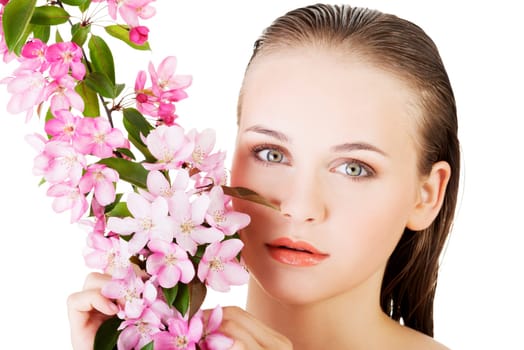 Beautiful face of spa woman with healthy clean skin and pink flowers. Isolated on white.