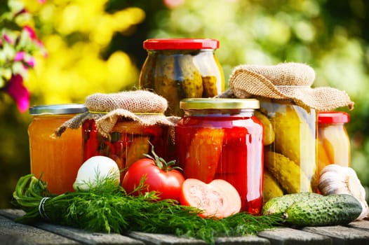 Jars of pickled vegetables in the garden. Marinated food