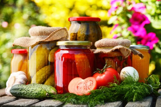 Jars of pickled vegetables in the garden. Marinated food