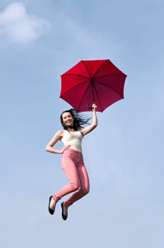 Woman jumps with umbrella