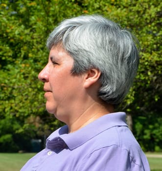 Older woman sitting on bench, profile view