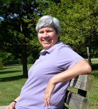 Older woman sitting on bench and smiling
