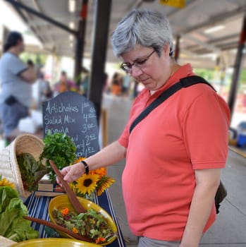Woman at greens stand in farmers market