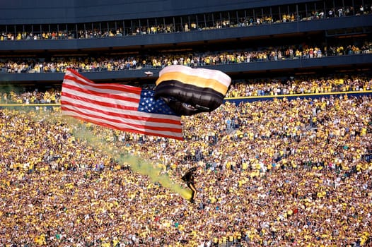 ANN ARBOR, MI - OCTOBER 09: 101st Airborne Division Parachute Demonstration Team member parachutes past the crowd at Michigan Stadium before the Michigan vs. Michigan State football game October 9, 2010.