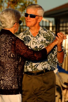 Senior couple dancing, with sunglasses
